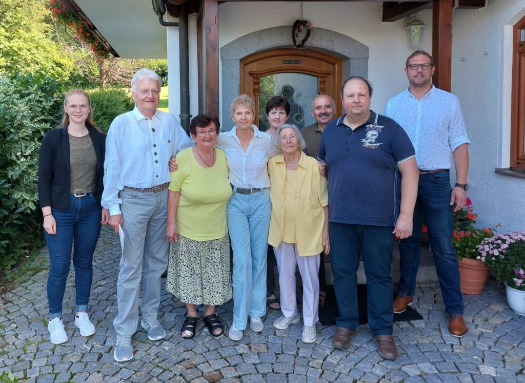 Die Gruppe aus Geehrten und Gratulanten steht vor dem Berghof Plenk.