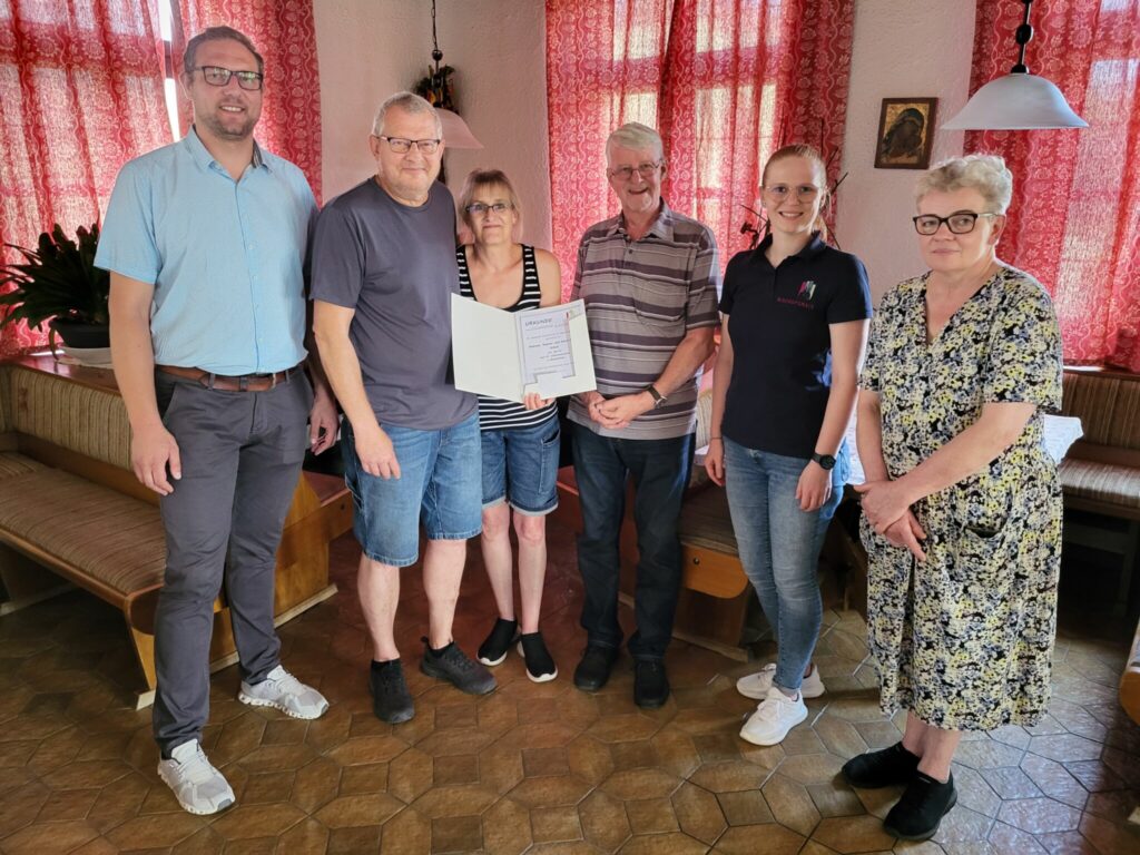Die Geehrten und die Gratulanten stehen zum Gruppenfoto in der Pension "Alte Post".