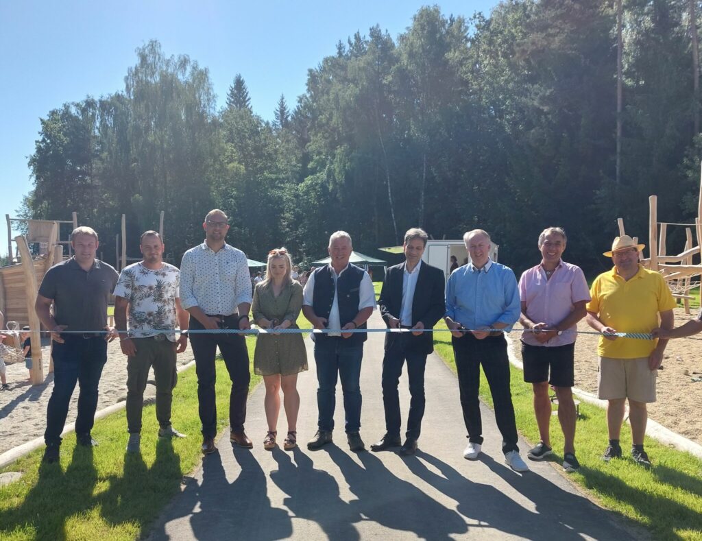 Jugendbeauftragter Johann Trum, Polier Patrick Lang (Firma Detzer), dritter Bürgermeister Stefan Kern, Bauleiterin Julia Frauenauer (Firma Detzer), Bürgermeister Walter Nirschl, Oliver Seischab von der Regierung von Niederbayern, zweiter Bürgermeister und stellvertretender Landrat Helmut Plenk, Planer Hans Nicklas von der Architekturschmiede und sein Kollege Stefan Mader eröffnen den Spielplatz mit dem Durchschneides des Bandes.